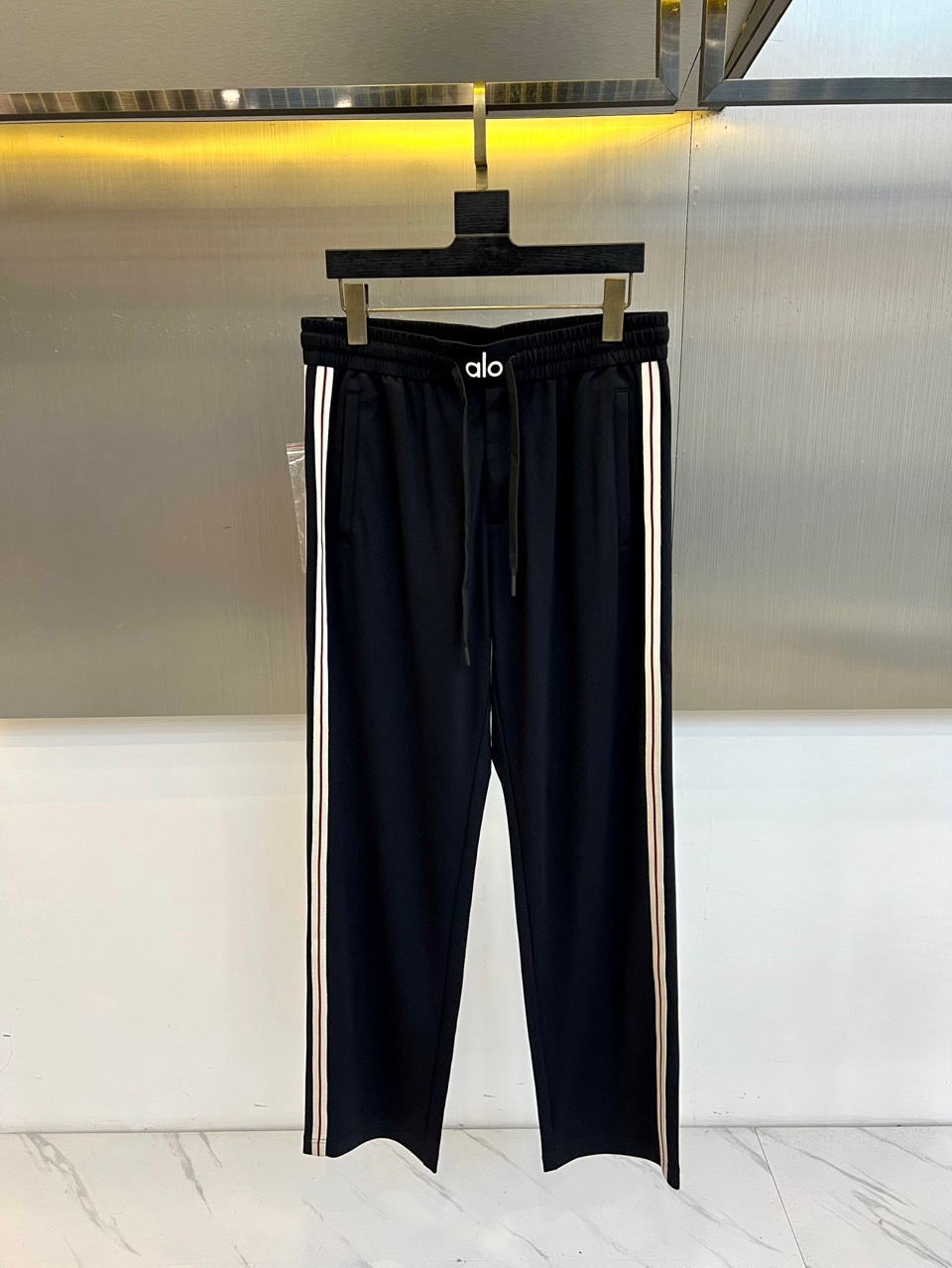 ALO-2026春夏系列男士运动裤，以简约廓形融合功能细节，打造全天候舒适着装。经典抽绳腰头设计，便于调