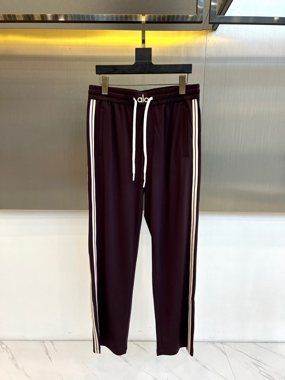 ALO-2026春夏系列男士运动裤，以简约廓形融合功能细节，打造全天候舒适着装。经典抽绳腰头设计，便于调