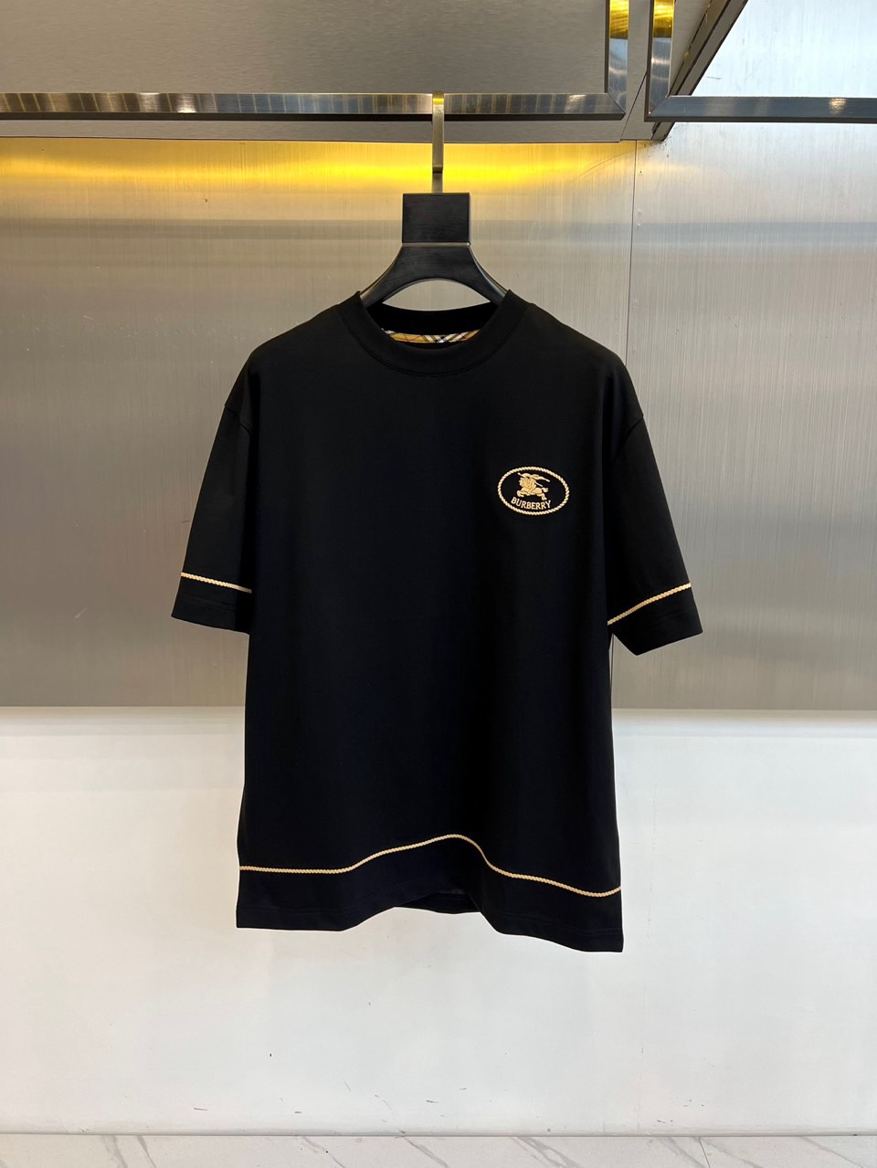 Bur巴宝莉、2026春夏男士T恤，以经典圆领与合身短袖剪裁，呈现简约利落的现代廓形。设计精髓凝聚于左胸