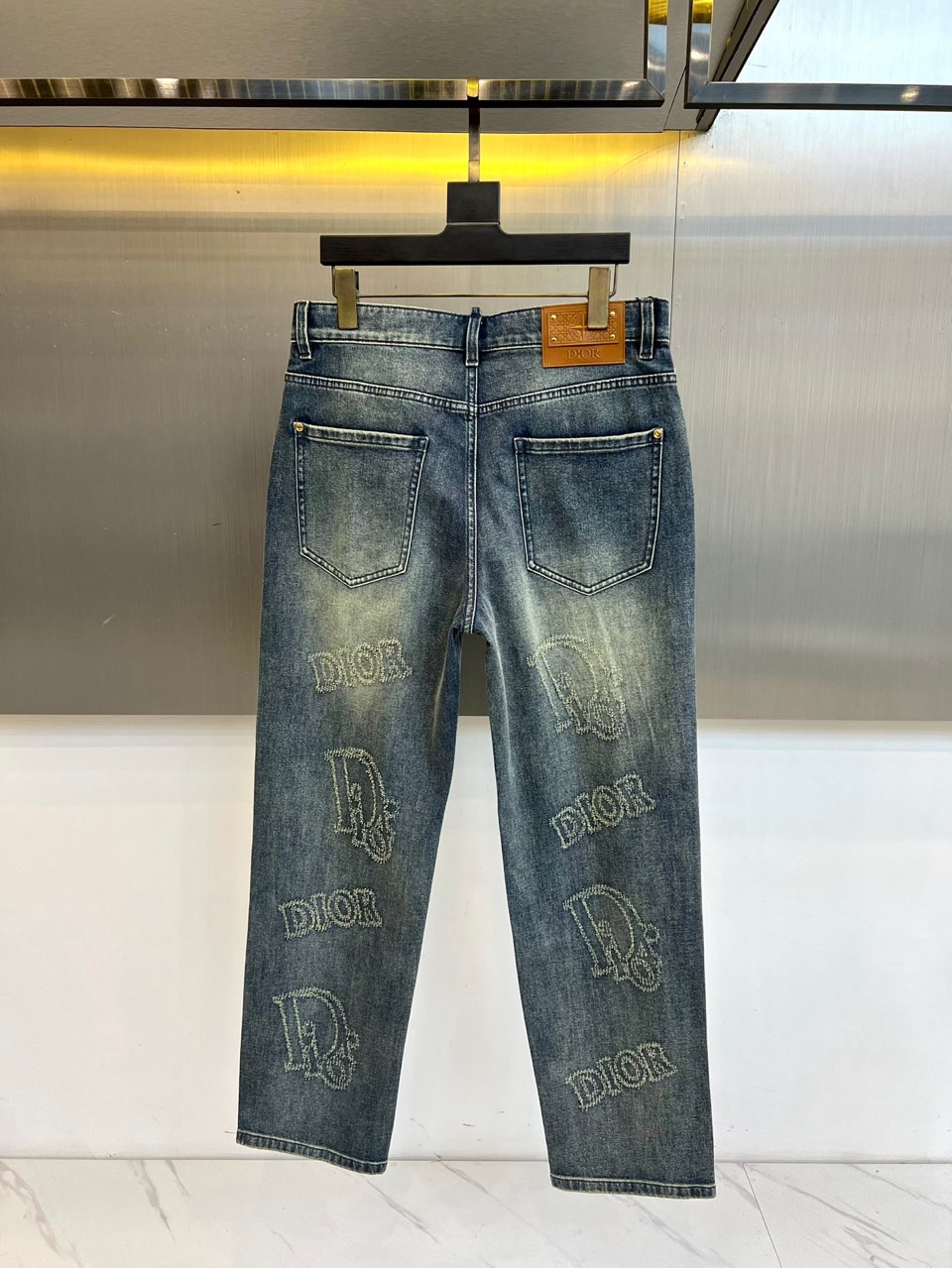 Dio迪奥、2026春夏新品牛仔裤，以潮流满印设计为视觉核心，裤身布满品牌标志性字母图案，做旧水洗工艺赋