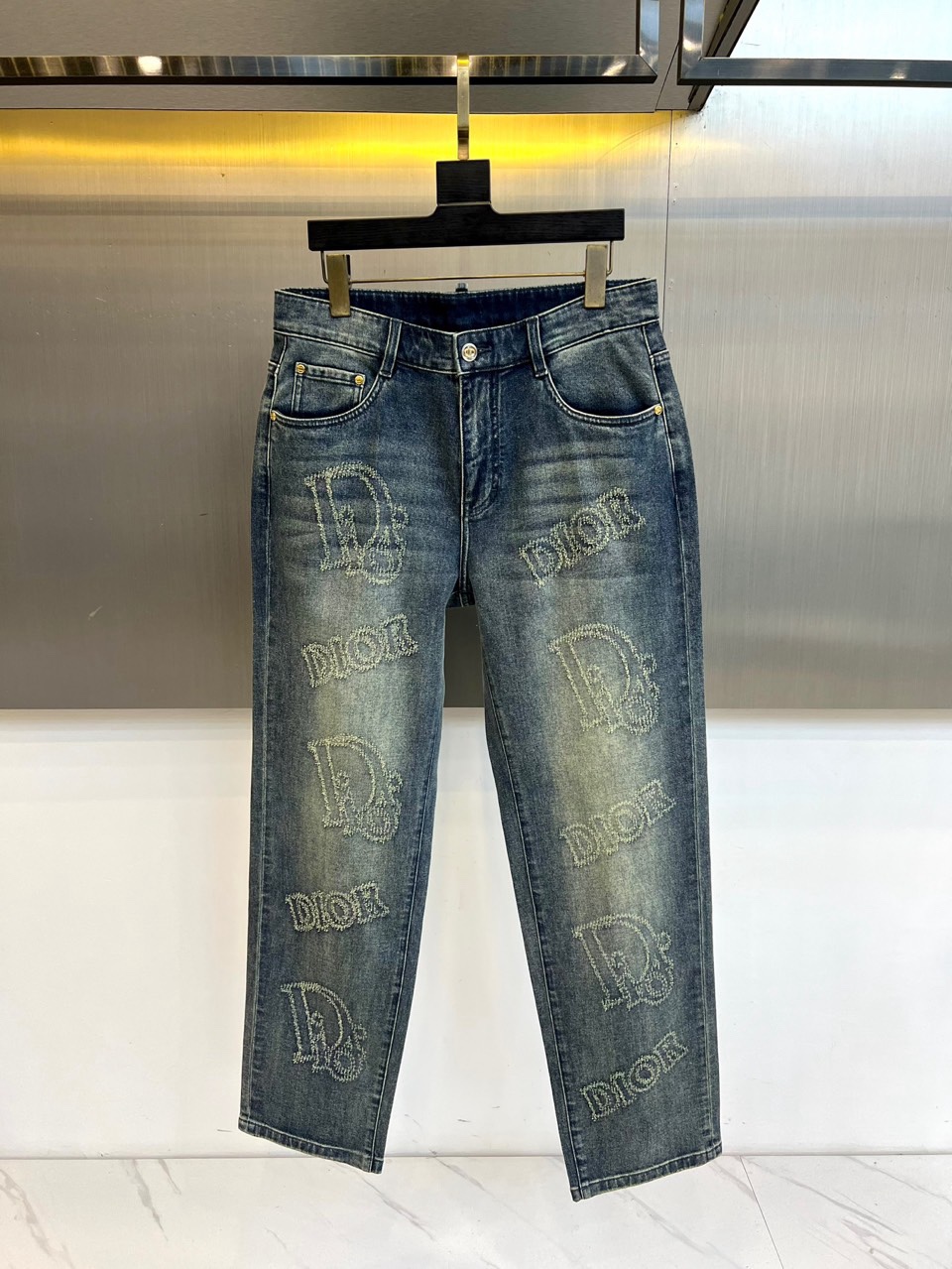 Dio迪奥、2026春夏新品牛仔裤，以潮流满印设计为视觉核心，裤身布满品牌标志性字母图案，做旧水洗工艺赋