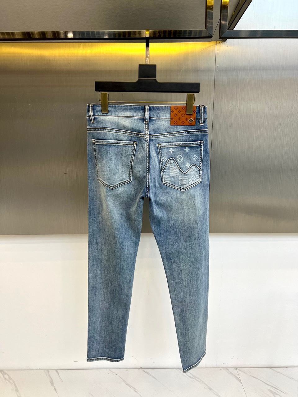 1v威登、2026春夏男士牛仔裤，以解构手法重塑品牌标志美学。款式采用经典五袋设计，修身剪裁精准勾勒利落