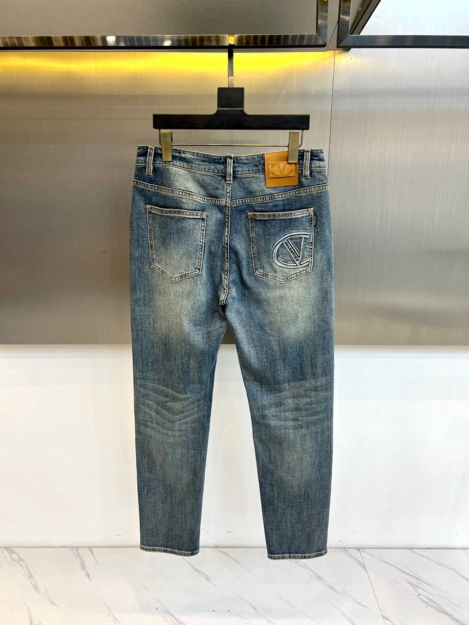 TV华伦天奴、2026春夏新品牛仔裤，以标志性的后袋徽章刺绣彰显奢华街头风格。圆形徽标内精绣品牌“V”字