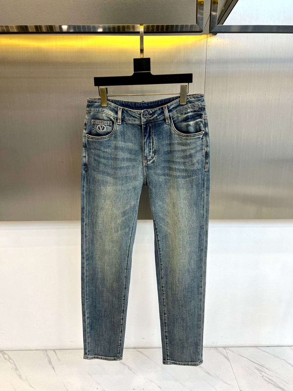 TV华伦天奴、2026春夏新品牛仔裤，以标志性的后袋徽章刺绣彰显奢华街头风格。圆形徽标内精绣品牌“V”字