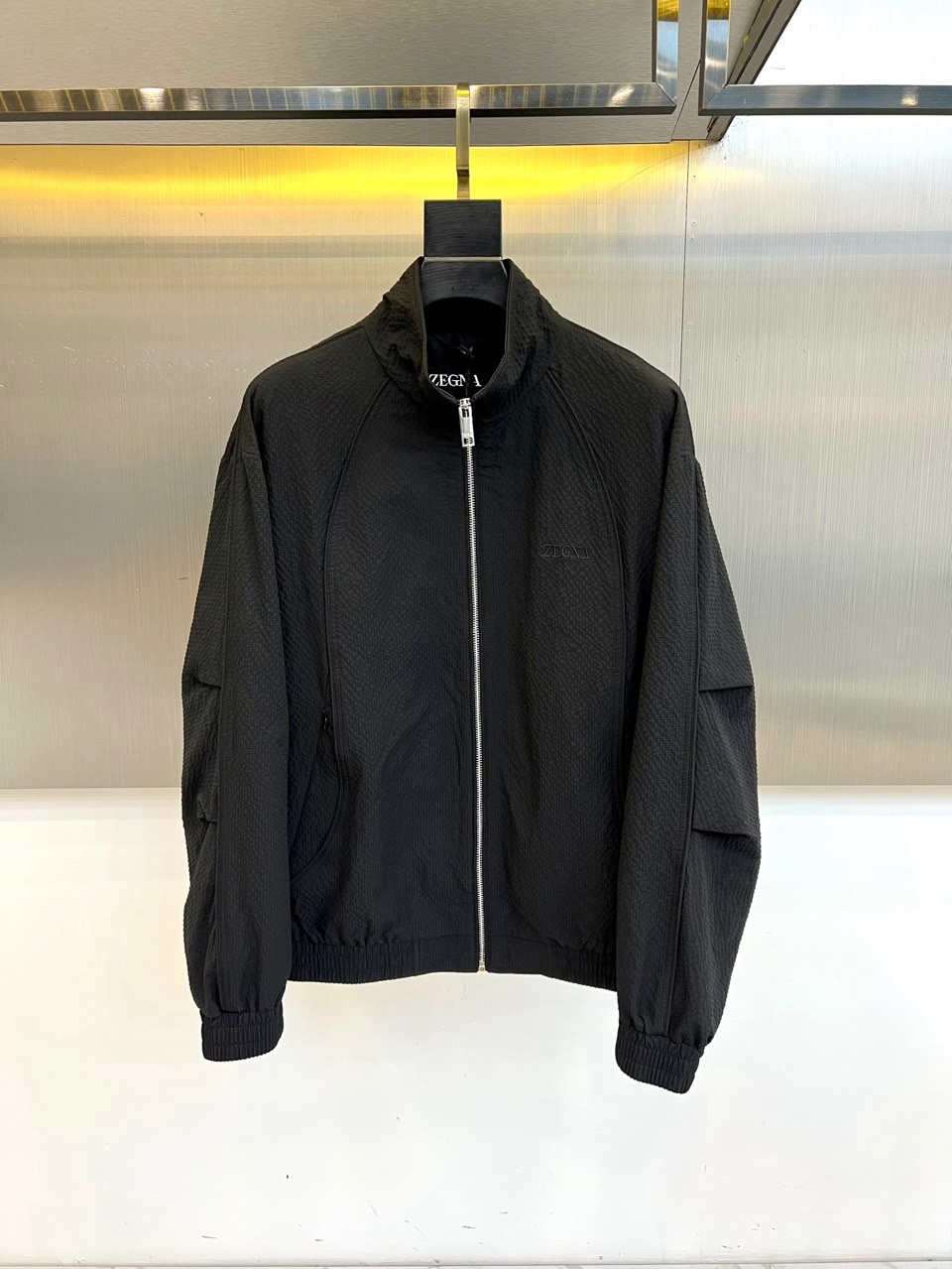 Zegna杰尼亚、2026春夏新品夹克，以简约立领与顺滑拉链开合，定义都市利落廓形。衣袖处独特的拼接细节