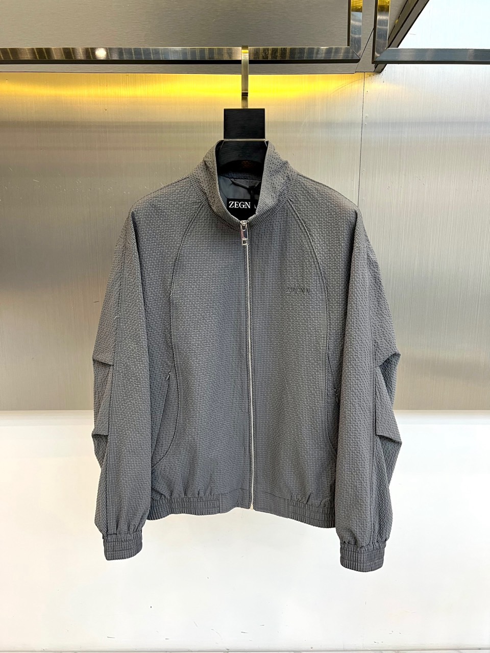 Zegna杰尼亚、2026春夏新品夹克，以简约立领与顺滑拉链开合，定义都市利落廓形。衣袖处独特的拼接细节