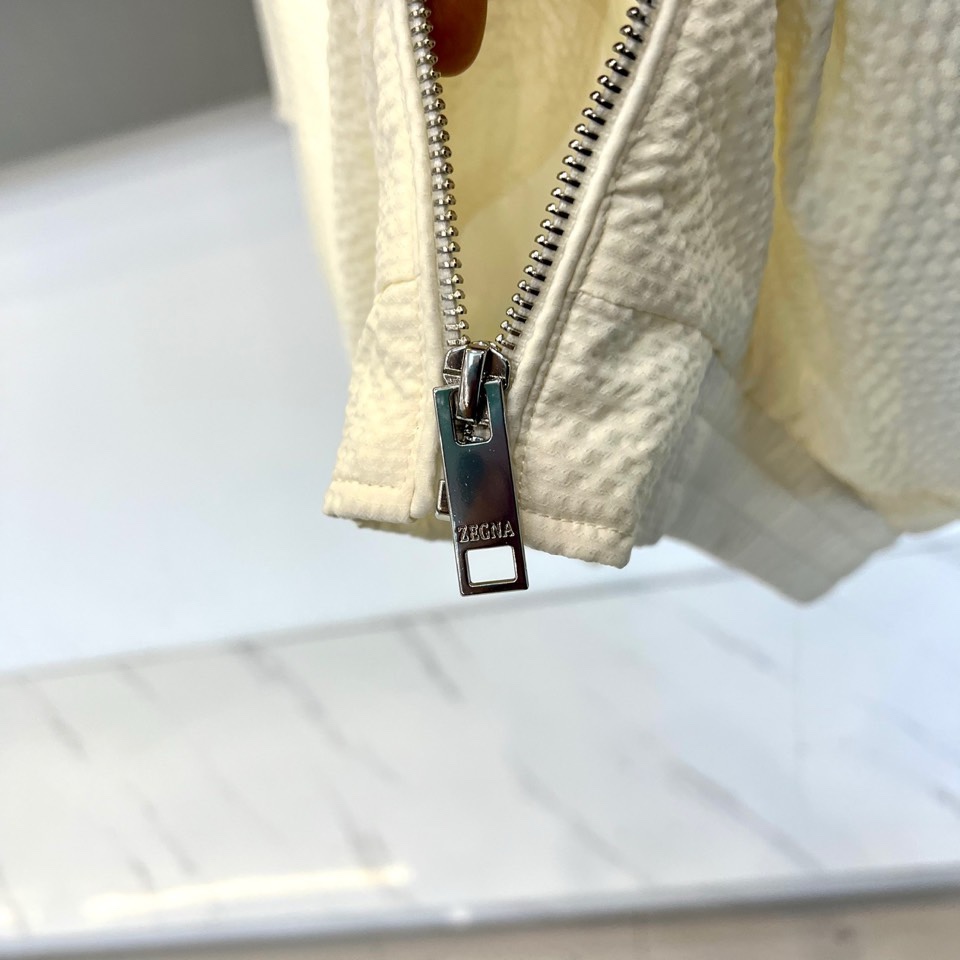 Zegna杰尼亚、2026春夏新品夹克，以简约立领与顺滑拉链开合，定义都市利落廓形。衣袖处独特的拼接细节