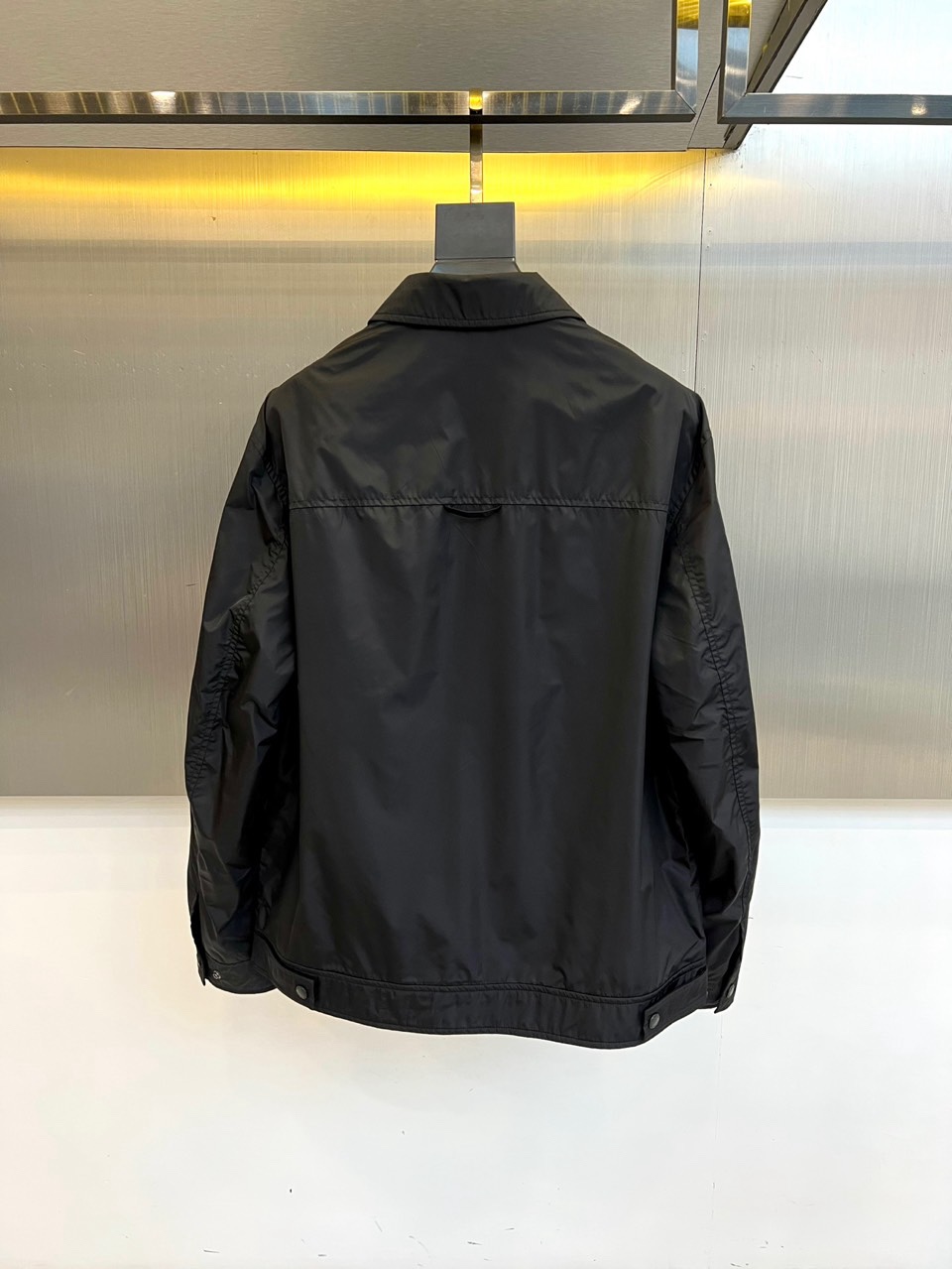 Prad普拉达、2026春夏男士夹克，以简约线条重塑都市机能美学。款式采用经典翻领与顺滑拉链开合，线条利