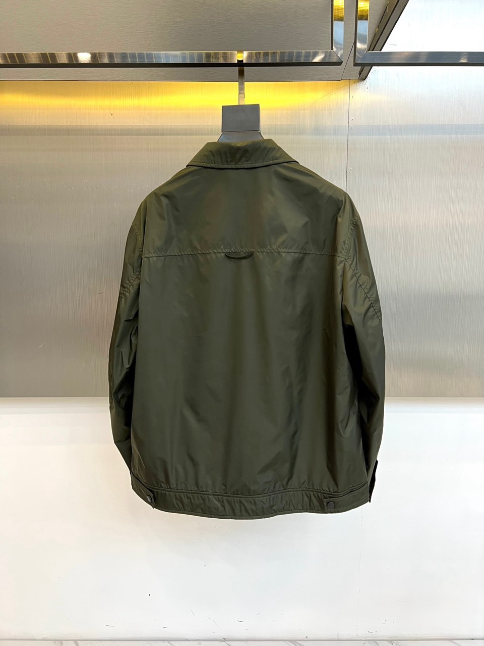 Prad普拉达、2026春夏男士夹克，以简约线条重塑都市机能美学。款式采用经典翻领与顺滑拉链开合，线条利