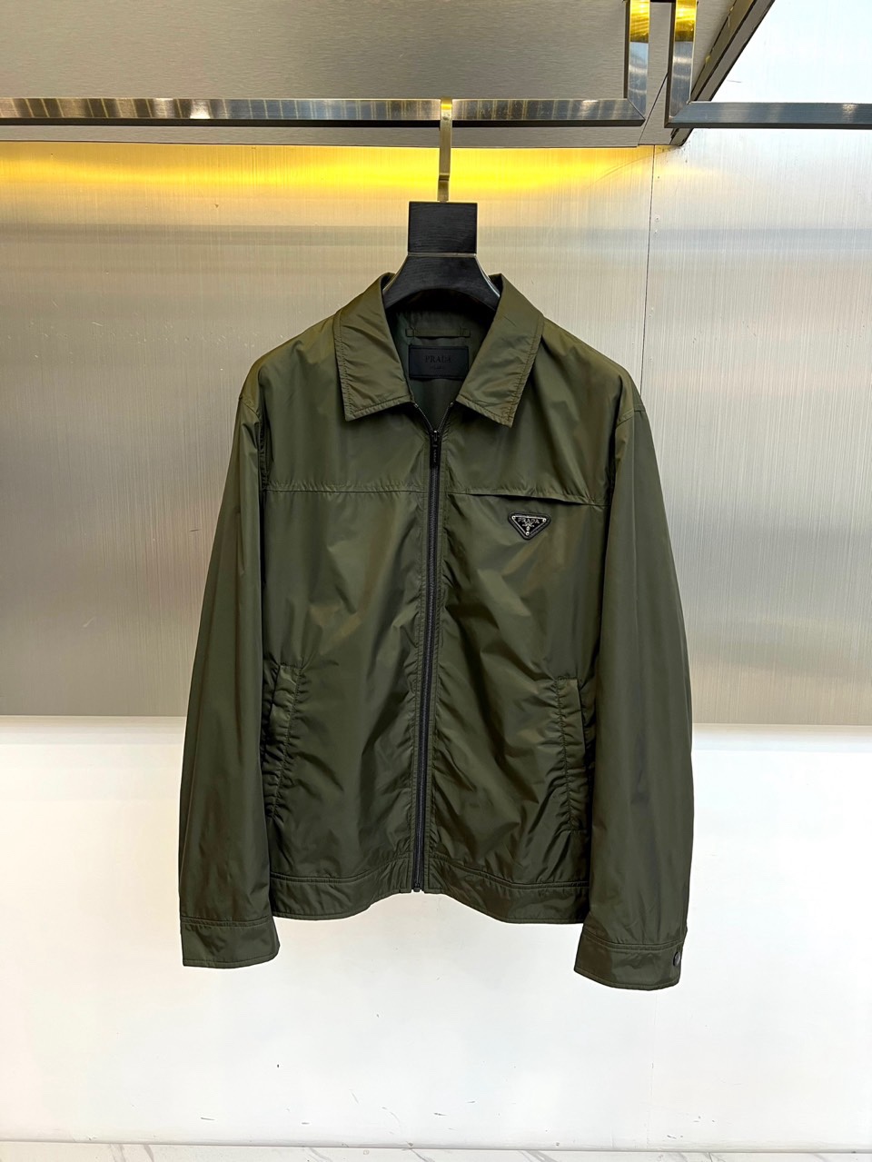 Prad普拉达、2026春夏男士夹克，以简约线条重塑都市机能美学。款式采用经典翻领与顺滑拉链开合，线条利