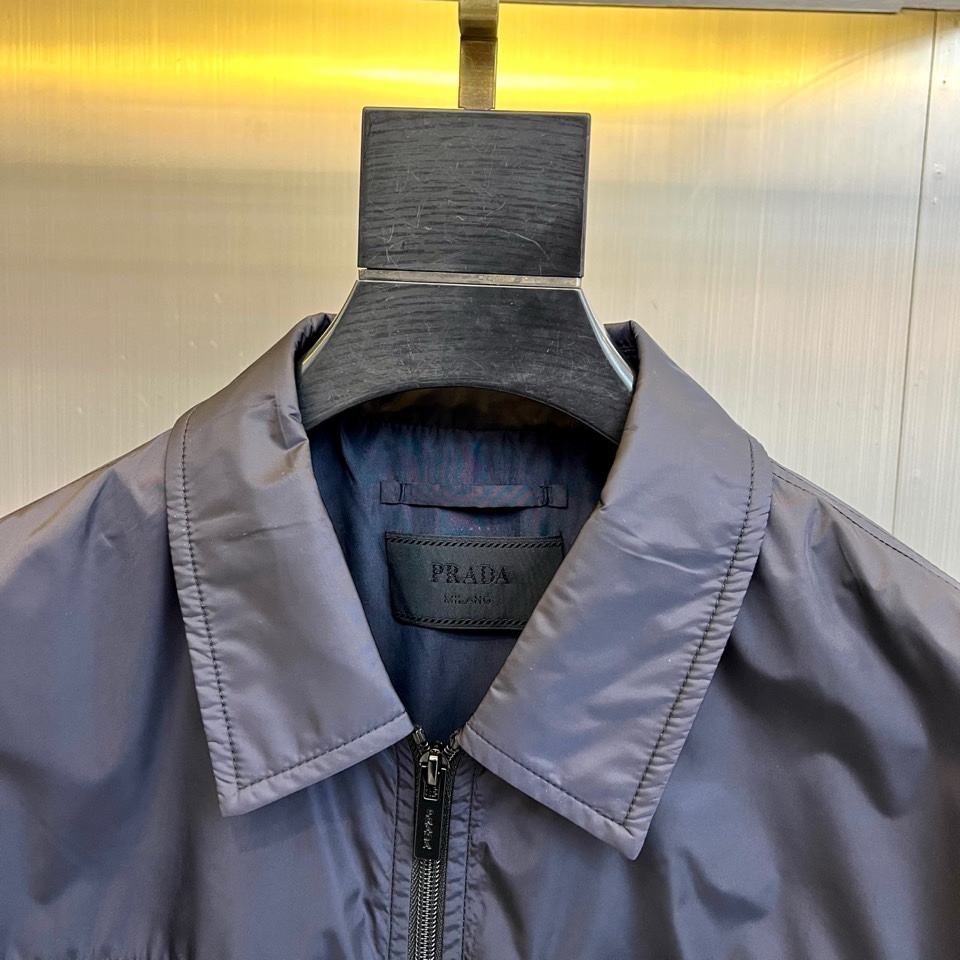 Prad普拉达、2026春夏男士夹克，以简约线条重塑都市机能美学。款式采用经典翻领与顺滑拉链开合，线条利
