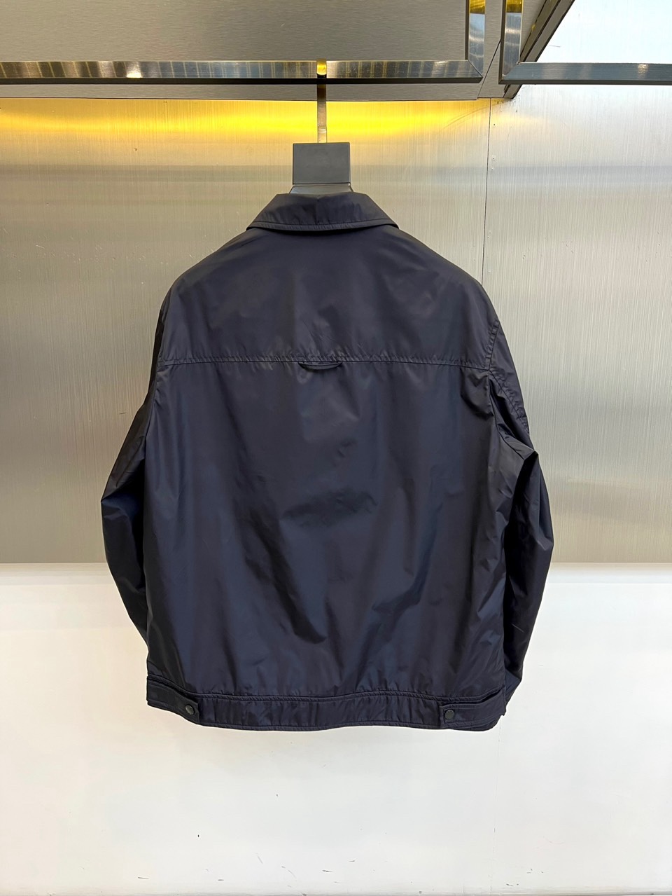 Prad普拉达、2026春夏男士夹克，以简约线条重塑都市机能美学。款式采用经典翻领与顺滑拉链开合，线条利