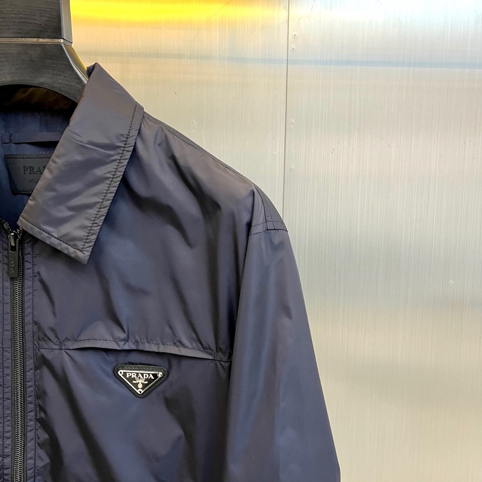Prad普拉达、2026春夏男士夹克，以简约线条重塑都市机能美学。款式采用经典翻领与顺滑拉链开合，线条利