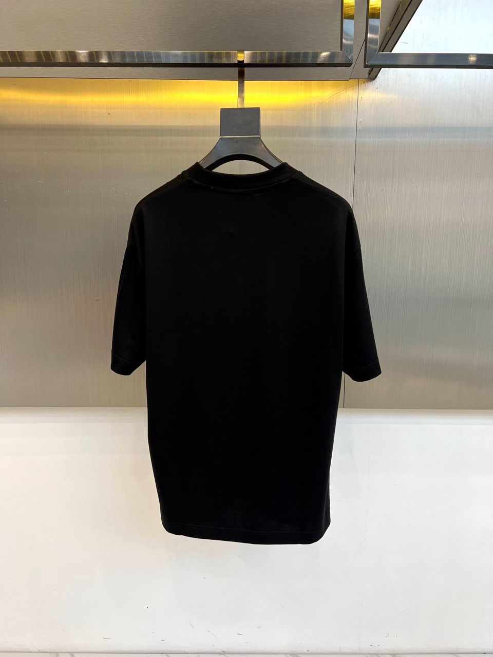 Mon蒙口、2026春夏T恤，以经典圆领短袖廓形展现纯粹休闲感。设计焦点在于衣身正面的品牌标志性图案，由