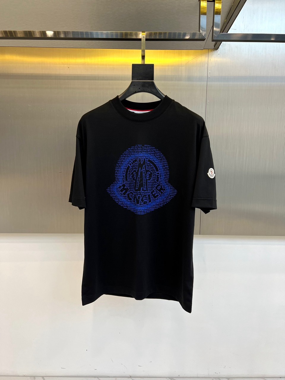 Mon蒙口、2026春夏T恤，以经典圆领短袖廓形展现纯粹休闲感。设计焦点在于衣身正面的品牌标志性图案，由