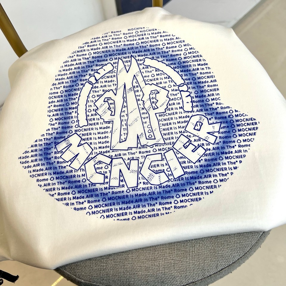 Mon蒙口、2026春夏T恤，以经典圆领短袖廓形展现纯粹休闲感。设计焦点在于衣身正面的品牌标志性图案，由