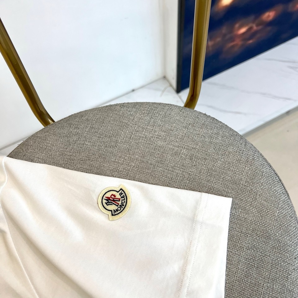 Mon蒙口、2026春夏T恤，以经典圆领短袖廓形展现纯粹休闲感。设计焦点在于衣身正面的品牌标志性图案，由