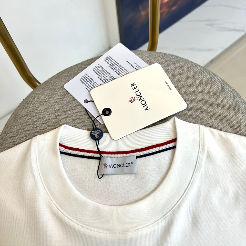 Mon蒙口、2026春夏T恤，以经典圆领短袖廓形展现纯粹休闲感。设计焦点在于衣身正面的品牌标志性图案，由