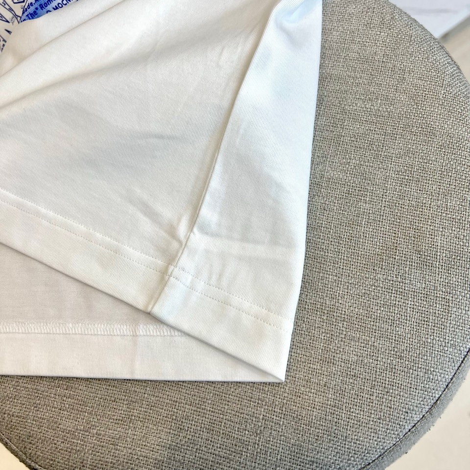 Mon蒙口、2026春夏T恤，以经典圆领短袖廓形展现纯粹休闲感。设计焦点在于衣身正面的品牌标志性图案，由