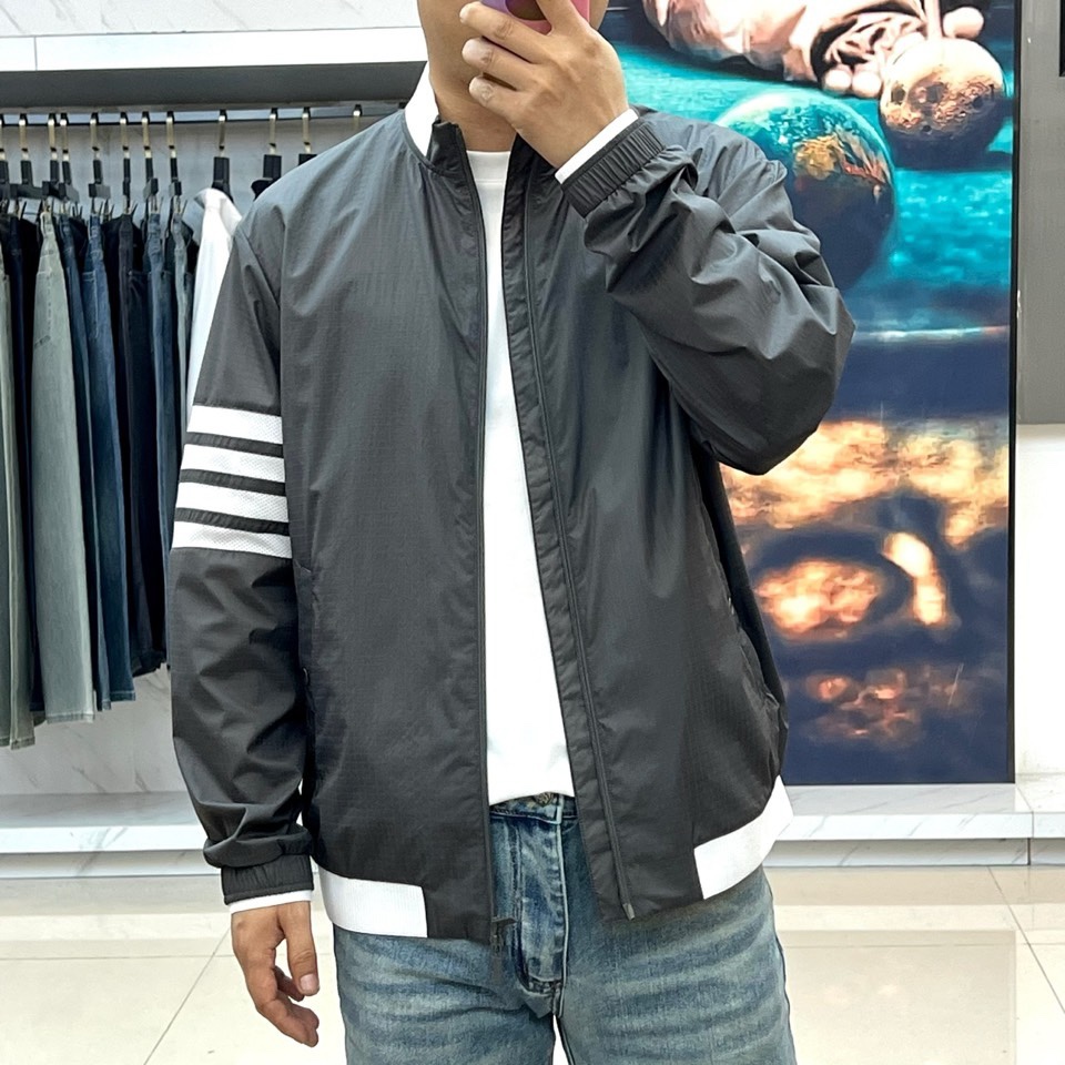 TB汤姆布朗、2026春夏新品夹克，以利落棒球领设计开篇，罗纹领口、下摆与袖口形成经典撞色，袖身四条条纹