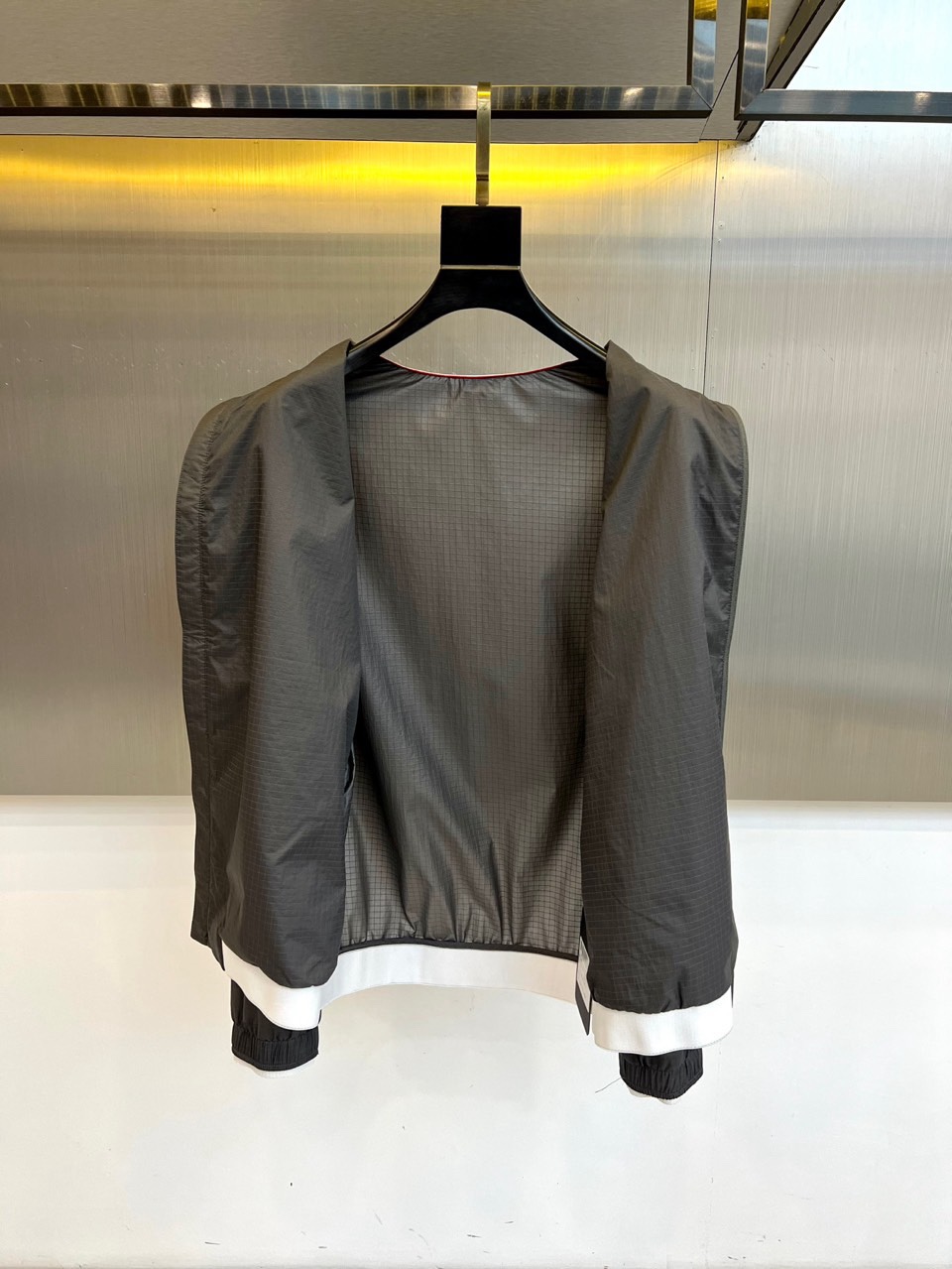 TB汤姆布朗、2026春夏新品夹克，以利落棒球领设计开篇，罗纹领口、下摆与袖口形成经典撞色，袖身四条条纹