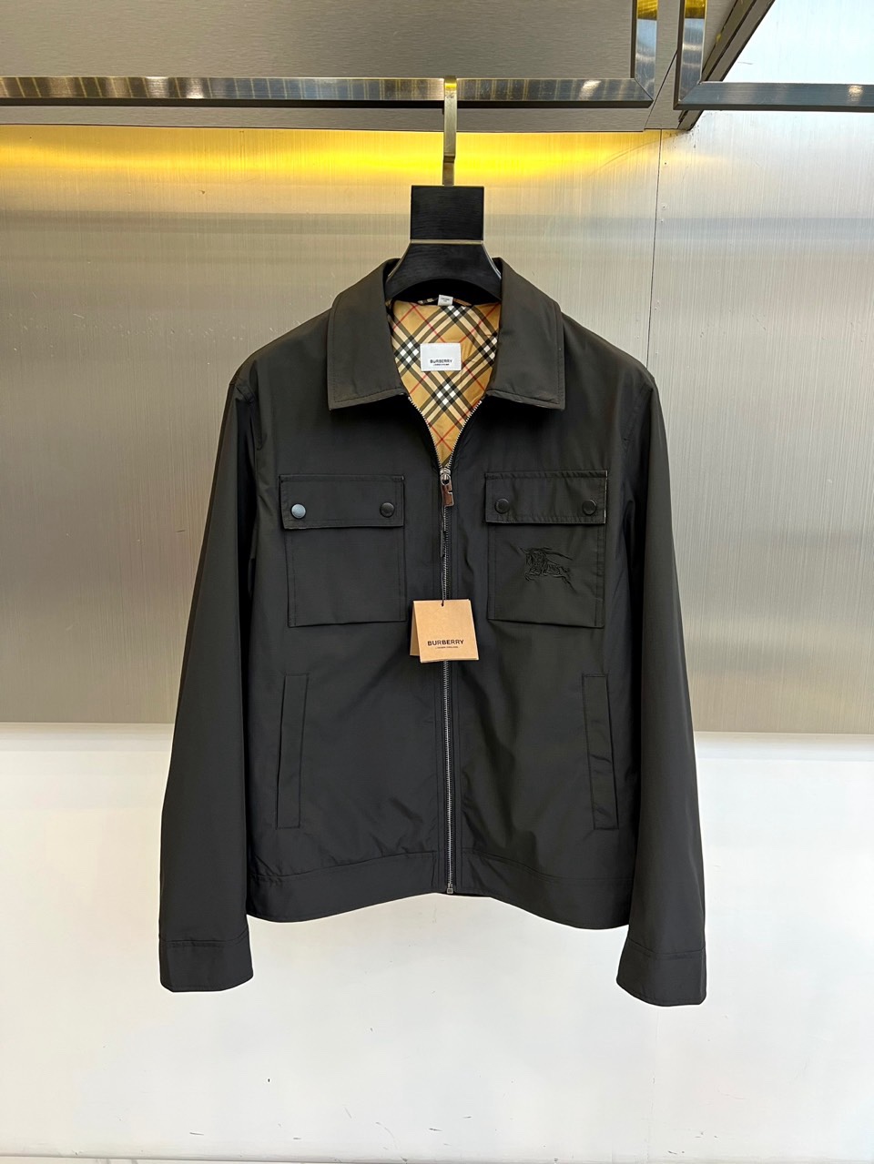 NO:760773,Burberry, 2026 spring and summer new jacket, with neat and stylish lapel design, classic plaid lining hidden brand genes. Front zipper closure, flap pockets on both sides with snap buttons, both practical and layered. The knight embroidered logo on the left chest is a low-key finishing touch, continuing the British heritage. The fabric is light and crisp, windproof and breathable, suitable for many spring and summer scenes. The cuffs and hem are closed to modify the body shape and enhance practicality. The overall style is integrated  It combines retro workwear and modern leisure. It can be paired with shirts, T-shirts or sweaters to easily manage commuting, traveling or light business occasions. It interprets high-end texture with a minimalist silhouette and shows a low-key luxury fashion attitude. It is an ideal choice for both practical wear and style in the spring and summer wardrobe. 48-56 (model is 173,143 pounds, upper body size 50),, burberry, burberry, jackets  & coats,shirts,tees,t-shirt,19860909Bur巴宝莉、2026春夏新品夹克,翻领设计利落有型,经典格纹内衬暗藏品牌基因.正面拉链开合,两侧翻盖口袋配按扣,兼具实用与层次感.左胸处骑士刺绣徽标低调点睛,延续英伦传承.面料轻盈挺括,防风透气适配春夏多场景.袖口与下摆收口设计,修饰身形且增强实用性.整体风格融合复古工装与现代休闲,可搭配衬衫、T恤或针织衫,轻松驾驭通勤、出游或轻商务场合.以极简廓形诠释高级质感,展现低调奢华的时尚态度,是春夏衣橱中兼具实穿与格调的理想之选.48-56（模特173,143斤上身50码）,,burberry,burberry,jackets & coats,shirts,tees，t-shirt,,Men's clothing