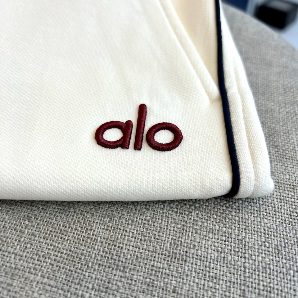 ALO、2026春夏新品休闲裤，简约运动弯刀裤。裤身侧边线条勾勒利落轮廓，增添视觉层次感；左腿处“alo