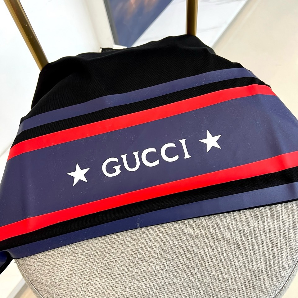 Gucc古驰、2026春夏新品短袖T恤，以经典纯色为底色，胸前横贯撞色条纹，中央“GUCCI”字样搭配两