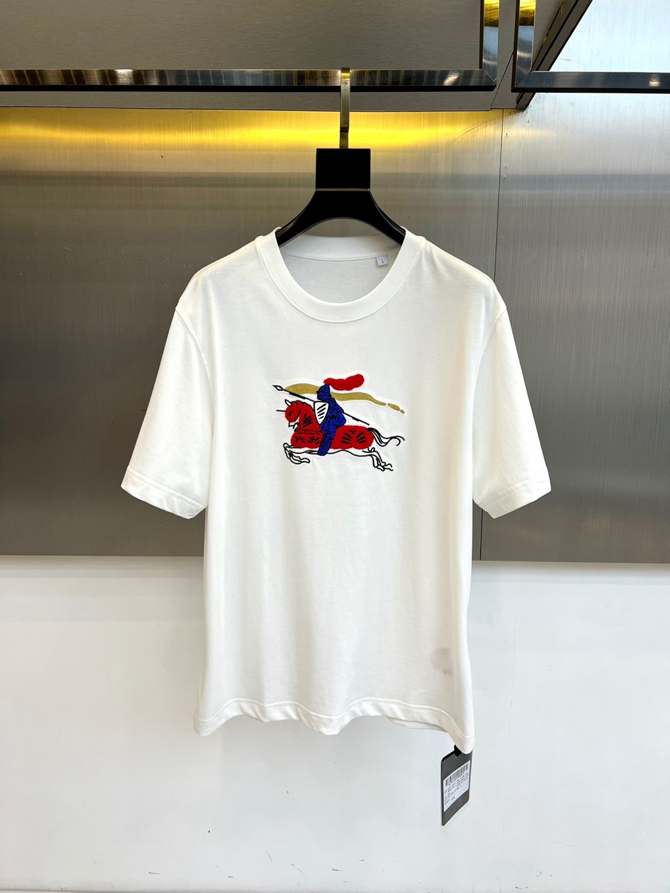 NO:773428,Burberry, 2026 spring and summer new short-sleeved T-shirt, made of pure cotton fabric, soft and skin-friendly, breathable and sweat-absorbent, classic round neck, simple and elegant, loose fit to adapt to various body shapes, casual and casual, while hiding body fat. The embroidered pattern on the chest has great visual tension, colliding the coolness of the classical chivalry spirit with the trendy street sense, breaking the monotony of traditional T-shirts, giving the single product artistic narrative and retro style. Whether it is paired with jeans to create an American casual style, or layered with a jacket to show a sophisticated look.  It has a sense of layering, or can be worn alone to highlight your personality. It can easily control scenes such as daily commuting, weekend outings, and fashionable gatherings. It makes spring and summer wear comfortable and comfortable, and it becomes the focus of attention with its unique embroidery. It redefines the trend possibilities of basic T-shirts and is a versatile weapon with both texture and style in the wardrobe. 48-56 (model is 173, 143 pounds, upper body size 50),, burberry, burberry, jeans, jackets  & coats,T-shirt,tees,t-shirt,19860909Bur巴宝莉、2026春夏新品短袖T恤,以纯棉面料打造,柔软亲肤、透气吸汗,经典圆领简约大气,宽松版型适配多元身形,休闲随性又藏肉显瘦.胸前刺绣图案极具视觉张力,将古典骑士精神的飒爽与潮流街头感碰撞,打破传统T恤的单调,赋予单品艺术叙事性与复古潮范.无论是搭配牛仔裤打造美式休闲风,还是叠穿外套演绎轻熟层次感,亦或单穿凸显个性态度,都能轻松驾驭日常通勤、周末出游、潮人聚会等场景,让春夏穿搭既舒适自在,又凭借独特刺绣成为吸睛焦点,重新定义基础款T恤的潮流可能性,是衣橱里兼具质感与风格的百搭利器.48-56（模特173,143斤上身50码）,,burberry,burberry,jeans,jackets & coats,T-shirt,tees，t-shirt,,Men's clothing