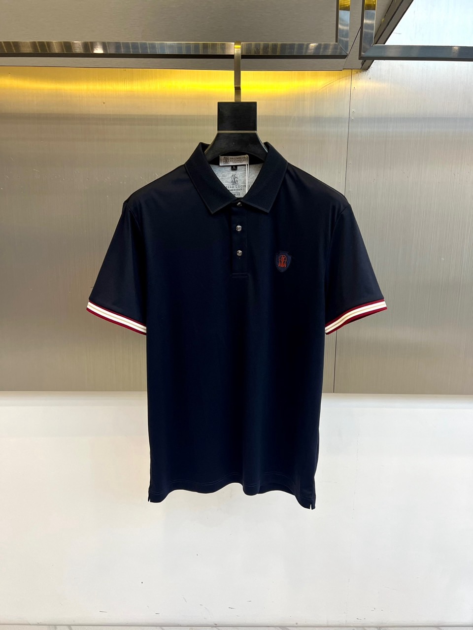 NO:773426,Brunello  Cucinelli-BC, 2026 spring and summer new men's short-sleeved POLO shirt, classic background contrasting cuffs, retro sports style and urban light luxury. The collar is crisp and not easy to deform, three exquisite buttons embellish the placket, and the embroidered badge on the left chest hides the brand  Craftsmanship, low-key to highlight identity. The body is made of pure cotton fabric, breathable and skin-friendly, sweat-absorbent and quick-drying, suitable for commuting, leisure, light sports and other scenarios. The micro-slit design at the hem enhances freedom of movement, and the details show tailoring skills. The overall shape is slim, not tight, and tolerant.  Easily create a neat and stylish silhouette for men. Whether you wear it with trousers for a business dinner or denim shorts for a weekend stroll, you can easily manage it. The care label indicates that it can be machine washed, but it is recommended to handle it gently at low temperature and avoid drying at high temperature to keep the texture of the fabric as new.  The new products of this season outline a sense of luxury with simple lines, and use classic elements to interpret modern trends. They are indispensable and versatile items in the wardrobe, and are also a good choice for gifts and personal use. M-4XL (model weighs 173,143 pounds, upper body size L),, brunello  cucinelli,shorts,T-shirt,19860909Brunello Cucinelli-BC、2026春夏新品男士短袖POLO衫,经典底色撞色袖口,复古运动风与都市轻奢感交融.领口挺括不易变形,三粒精致纽扣点缀门襟,左胸刺绣徽章暗藏品牌匠心,低调彰显身份.衣身采用纯棉面料,透气亲肤,吸汗速干,适配通勤、休闲、轻运动等多场景.下摆微开衩设计提升活动自由度,细节处尽显剪裁功力.整体版型修身不紧绷,包容性强,轻松打造利落型男轮廓.无论是搭配西裤出席商务简餐,还是配牛仔短裤漫步周末街头,都能从容驾驭.洗护标签注明可机洗但建议低温轻柔处理,避免高温烘干,保持面料质感持久如新.本季新品以简约线条勾勒高级感,用经典元素演绎现代潮流,是衣橱中不可或缺的百搭单品,亦是送礼自用皆宜的质感之选.M-4XL（模特173,143斤上身L码）,,brunello cucinelli,shorts,T-shirt,,Men's clothing