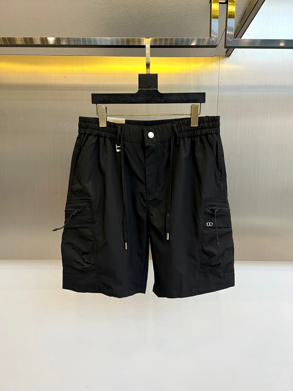 NO:918386,Dio, the new 2026 spring and summer work shorts, present a modern silhouette with classic five-quarter length and neat tailoring. Its style cleverly balances the tough functionality of work clothes with the brand's unique elegance, injecting casual charm into urban looks. The fabrics are made of high-quality materials, with a crisp texture and excellent breathability and wear resistance, ensuring comfortable and stylish wear. The details of the craftsmanship show ingenuity.  There is a built-in drawstring at the waist, which can be adjusted at will; the multi-functional patch pockets on both sides are practical and add layering, and the edges are outlined with exquisite decorative strips; high-quality metal fasteners are embellished with them, with an attractive luster. These shorts can be easily matched with all kinds of tops to create a variety of styles from casual to fashionable.. 48-56 (please quote waist size when placing an order),, dior, dior, shorts,19860909Dio迪奥、2026春夏新品工装短裤,以经典五分长度与利落剪裁呈现现代廓形.其风格巧妙平衡工装的功能硬朗与品牌独有的高雅格调,为都市造型注入率性魅力.面料甄选上乘材质,质感挺括且具备优异的透气性与耐磨度,确保穿着舒适有型.细节工艺尽显匠心腰部内置抽绳,可随心调节松紧；两侧多功能贴袋实用且增添层次,边缘以精致饰条勾勒；高品质金属扣件点缀其间,光泽动人.这款短裤能轻松搭配各类上装,塑造从休闲到时髦的多变风格..48-56（下单请报腰围尺寸）,,dior,dior,shorts,,Men's clothing