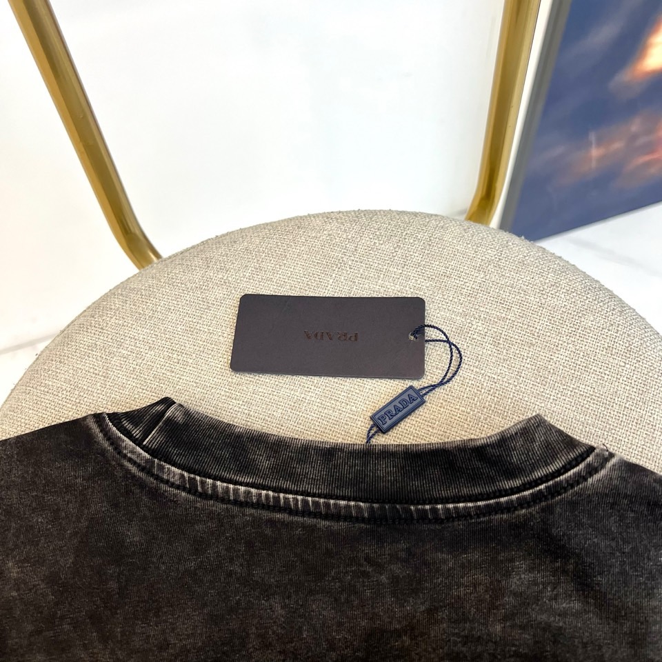 Prad普拉达、2026春夏新品短袖T恤重磅来袭！做旧水洗面料，自带复古滤镜与高级质感，每一寸纹理都藏着