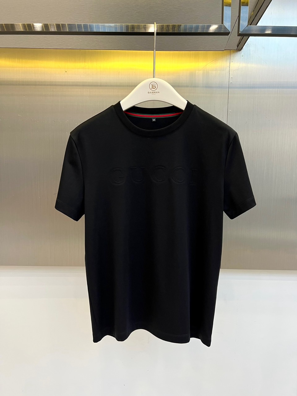 Gucc古驰、2026春夏新品短袖T恤，以纯色为基底，胸前采用立体压花工艺呈现品牌字母标识，简约中暗藏精