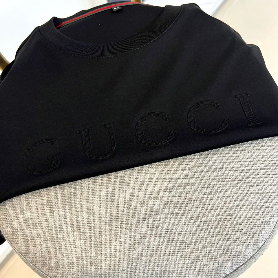 Gucc古驰、2026春夏新品短袖T恤，以纯色为基底，胸前采用立体压花工艺呈现品牌字母标识，简约中暗藏精