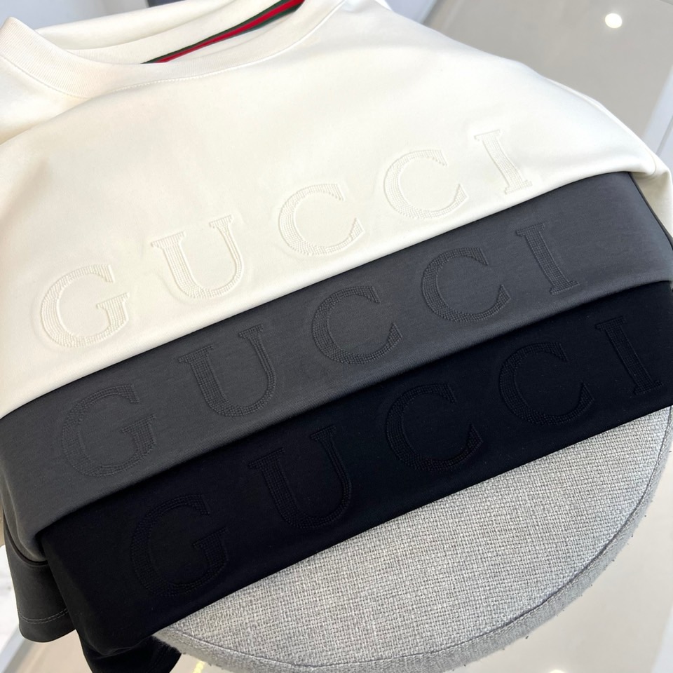 Gucc古驰、2026春夏新品短袖T恤，以纯色为基底，胸前采用立体压花工艺呈现品牌字母标识，简约中暗藏精