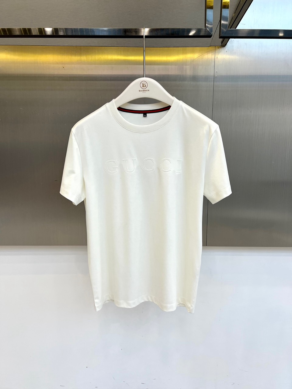 Gucc古驰、2026春夏新品短袖T恤，以纯色为基底，胸前采用立体压花工艺呈现品牌字母标识，简约中暗藏精