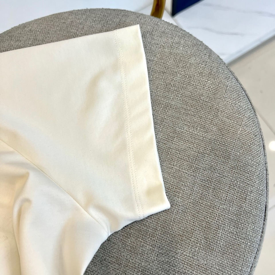 Gucc古驰、2026春夏新品短袖T恤，以纯色为基底，胸前采用立体压花工艺呈现品牌字母标识，简约中暗藏精