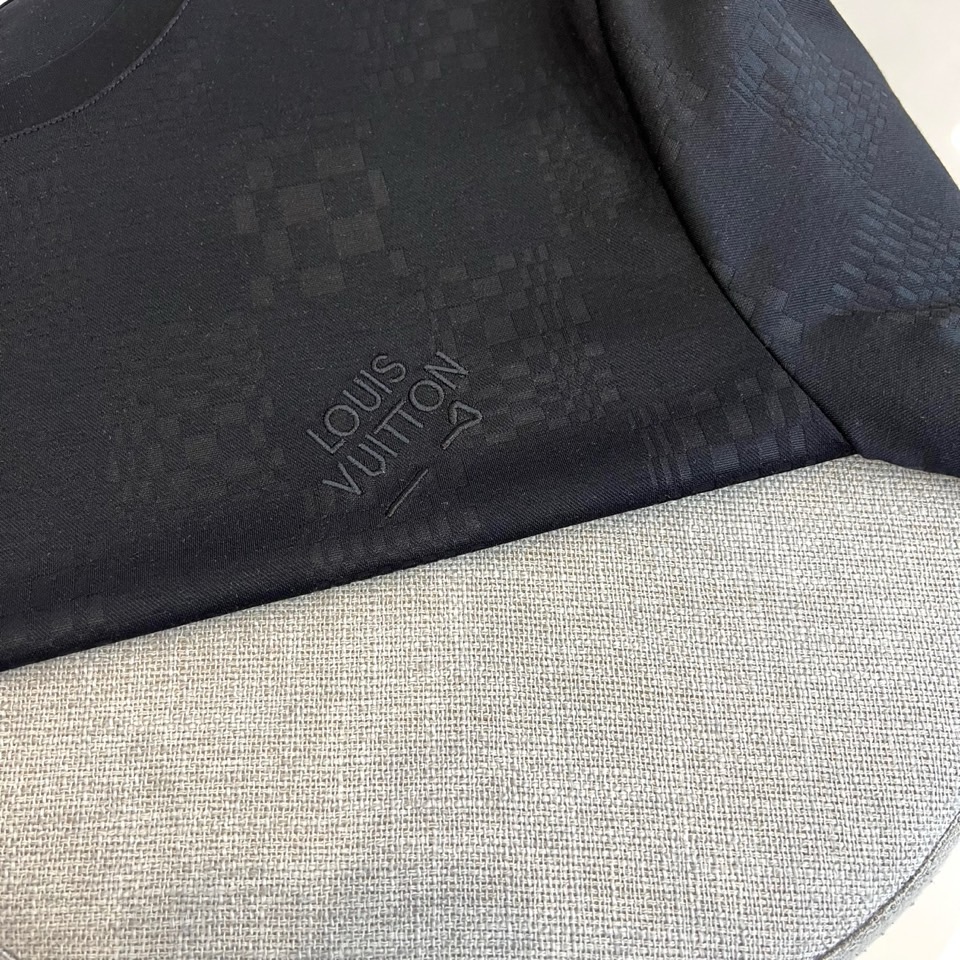 1v威登、2026春夏新品短袖T恤，以纯色为基底，满幅暗纹棋盘格肌理低调奢华，胸前精致字母刺绣点缀，简约