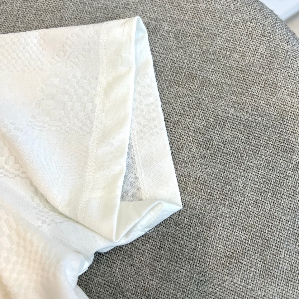 1v威登、2026春夏新品短袖T恤，以纯色为基底，满幅暗纹棋盘格肌理低调奢华，胸前精致字母刺绣点缀，简约