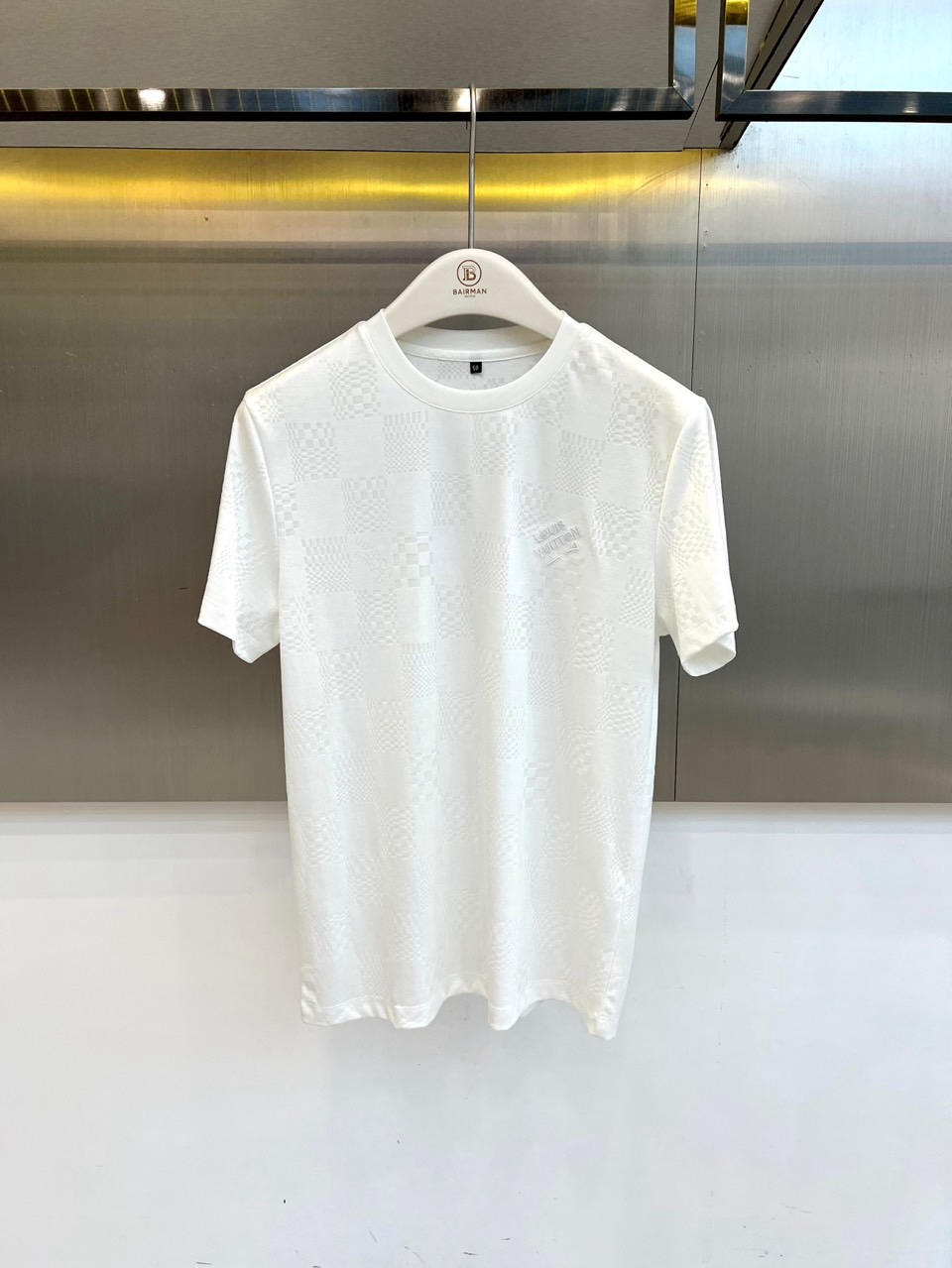 1v威登、2026春夏新品短袖T恤，以纯色为基底，满幅暗纹棋盘格肌理低调奢华，胸前精致字母刺绣点缀，简约