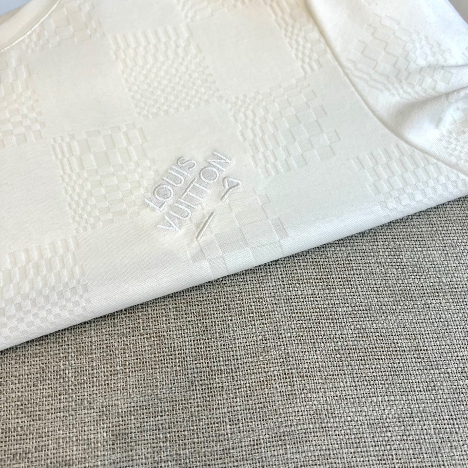 1v威登、2026春夏新品短袖T恤，以纯色为基底，满幅暗纹棋盘格肌理低调奢华，胸前精致字母刺绣点缀，简约