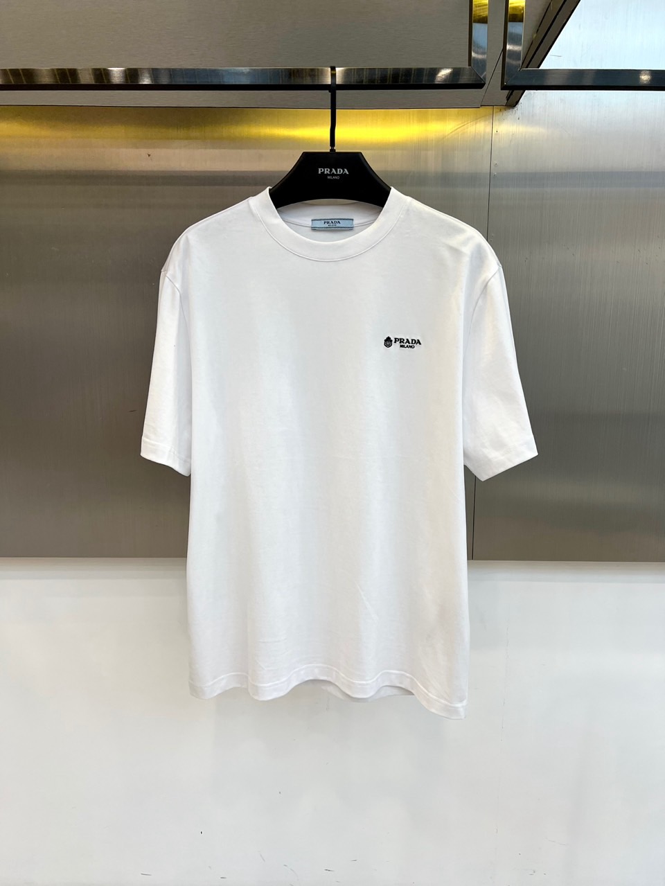 Prad普拉达、2026春夏新品短袖T恤，以利落圆领勾勒颈部线条，宽松剪裁赋予身体自由舒展空间，简约廓形