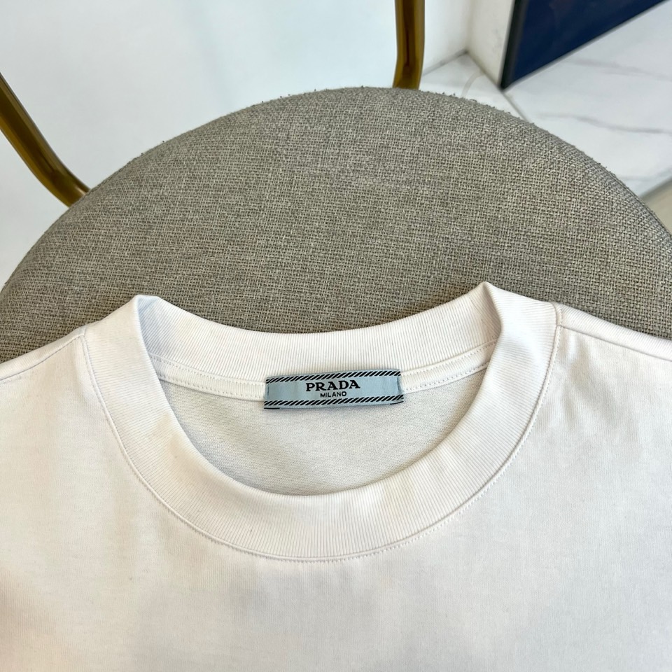 Prad普拉达、2026春夏新品短袖T恤，以利落圆领勾勒颈部线条，宽松剪裁赋予身体自由舒展空间，简约廓形