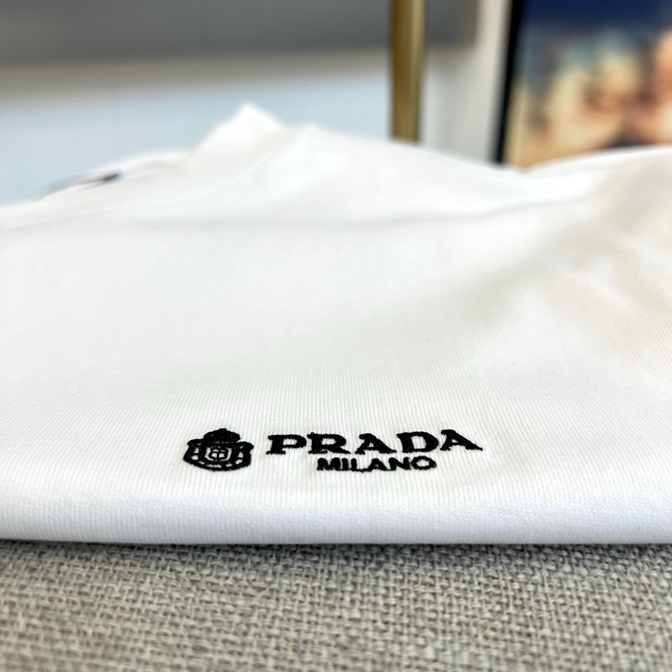 Prad普拉达、2026春夏新品短袖T恤，以利落圆领勾勒颈部线条，宽松剪裁赋予身体自由舒展空间，简约廓形