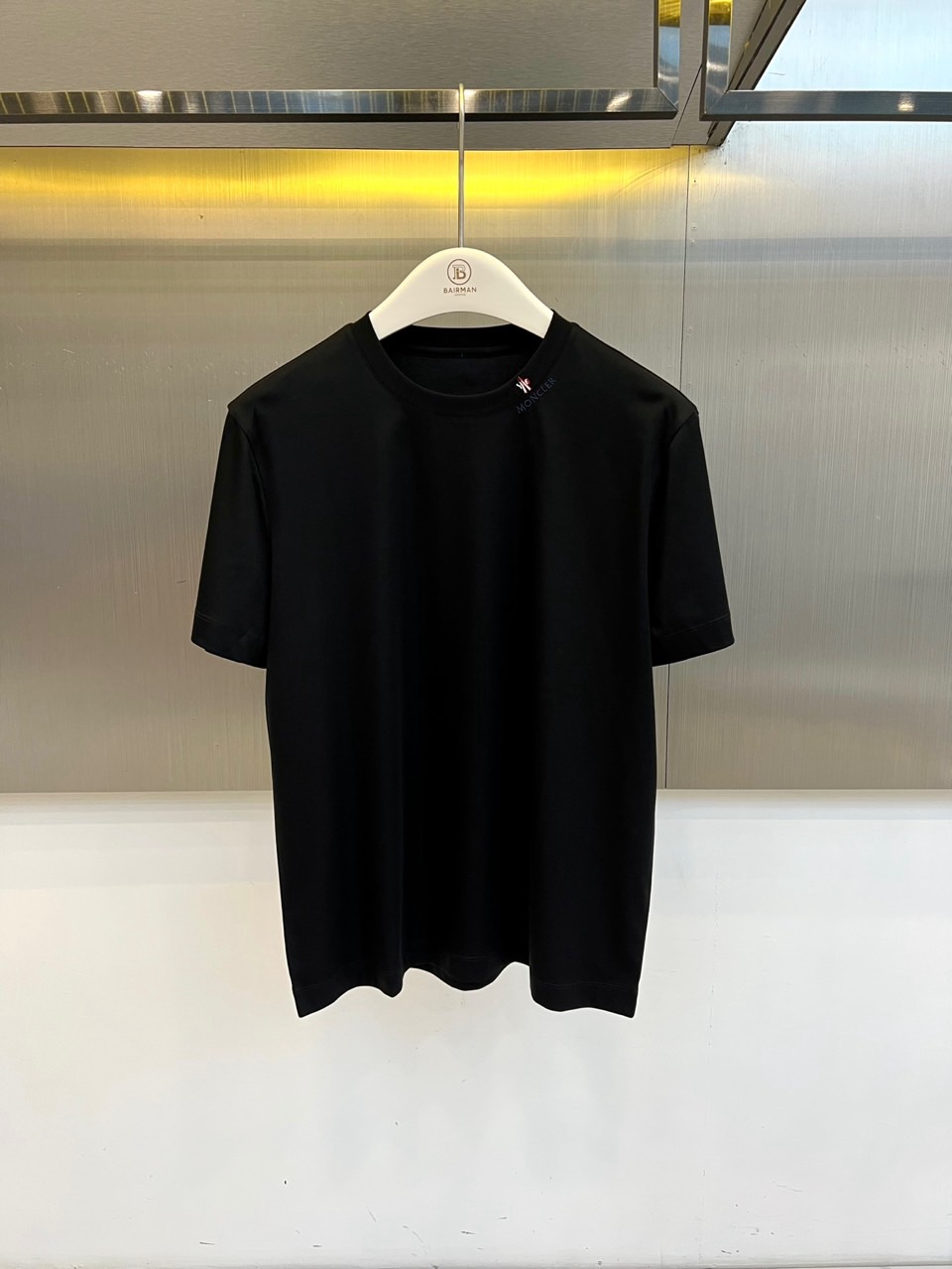 Mon蒙口、2026春夏新品短袖T恤，以纯色为基底，诠释极简主义美学。领子上精致字母标识点缀，低调彰显品