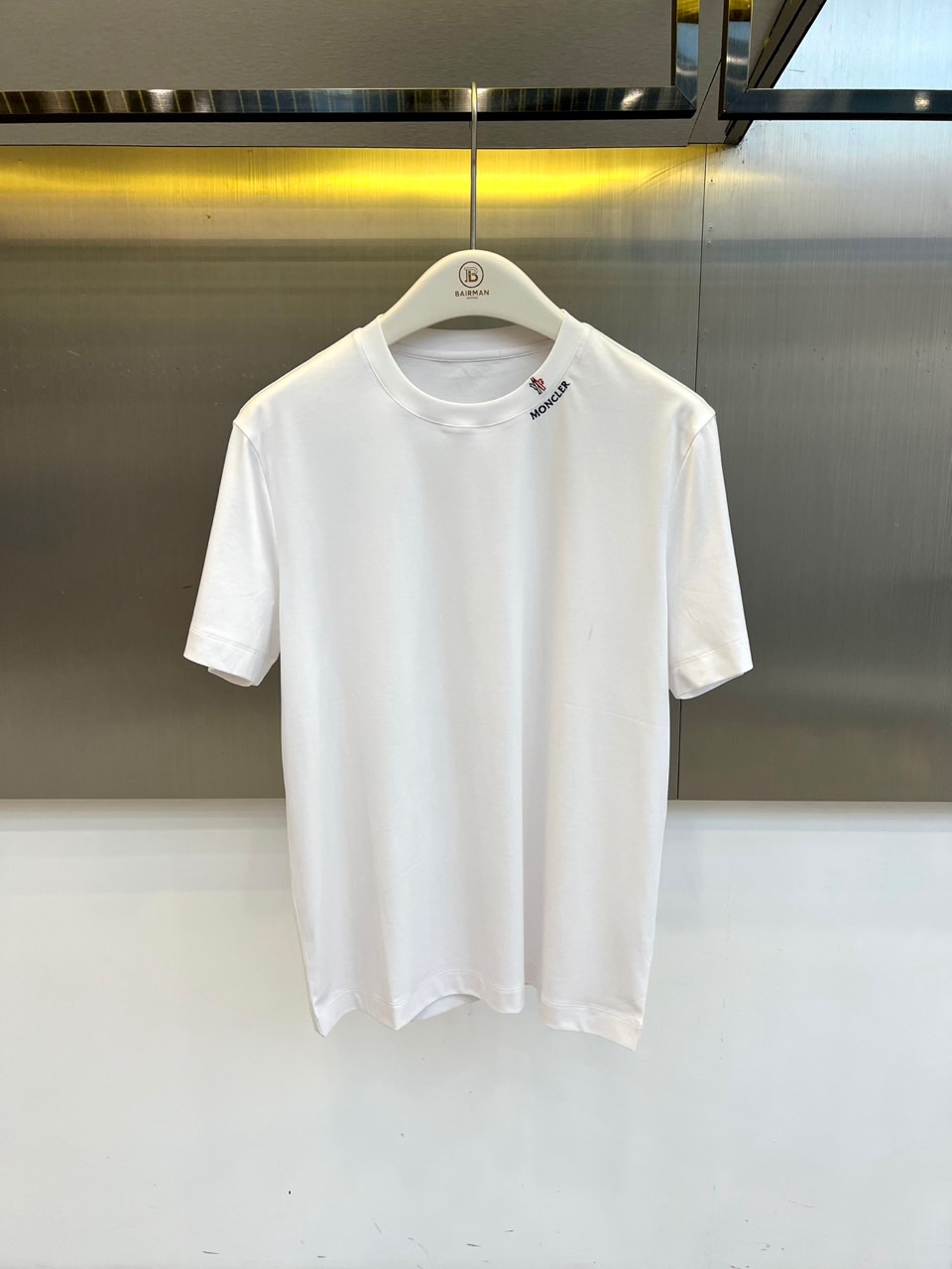Mon蒙口、2026春夏新品短袖T恤，以纯色为基底，诠释极简主义美学。领子上精致字母标识点缀，低调彰显品