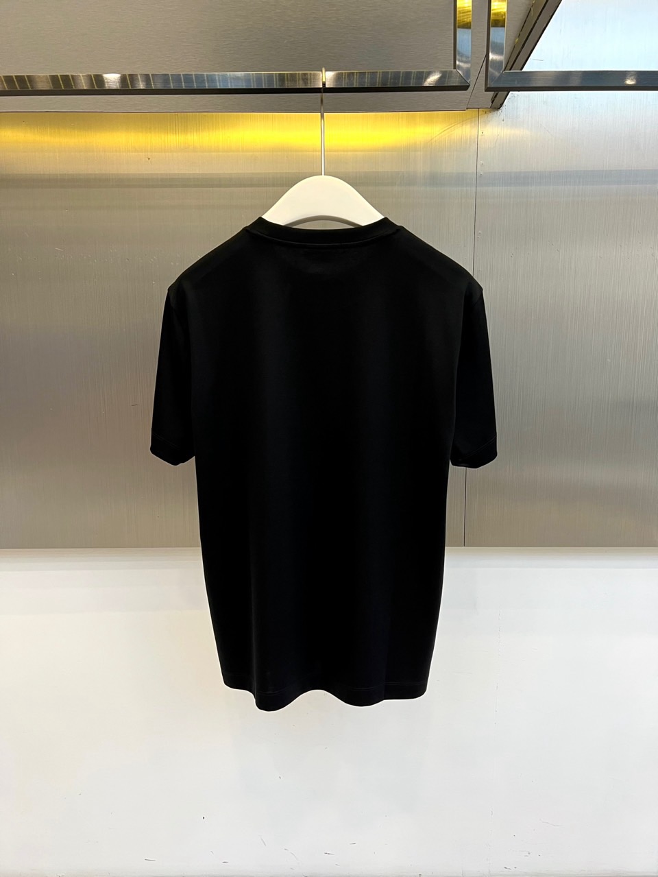 Mon蒙口、2026春夏新品短袖T恤，以纯色为基底，诠释极简主义美学。领子上精致字母标识点缀，低调彰显品