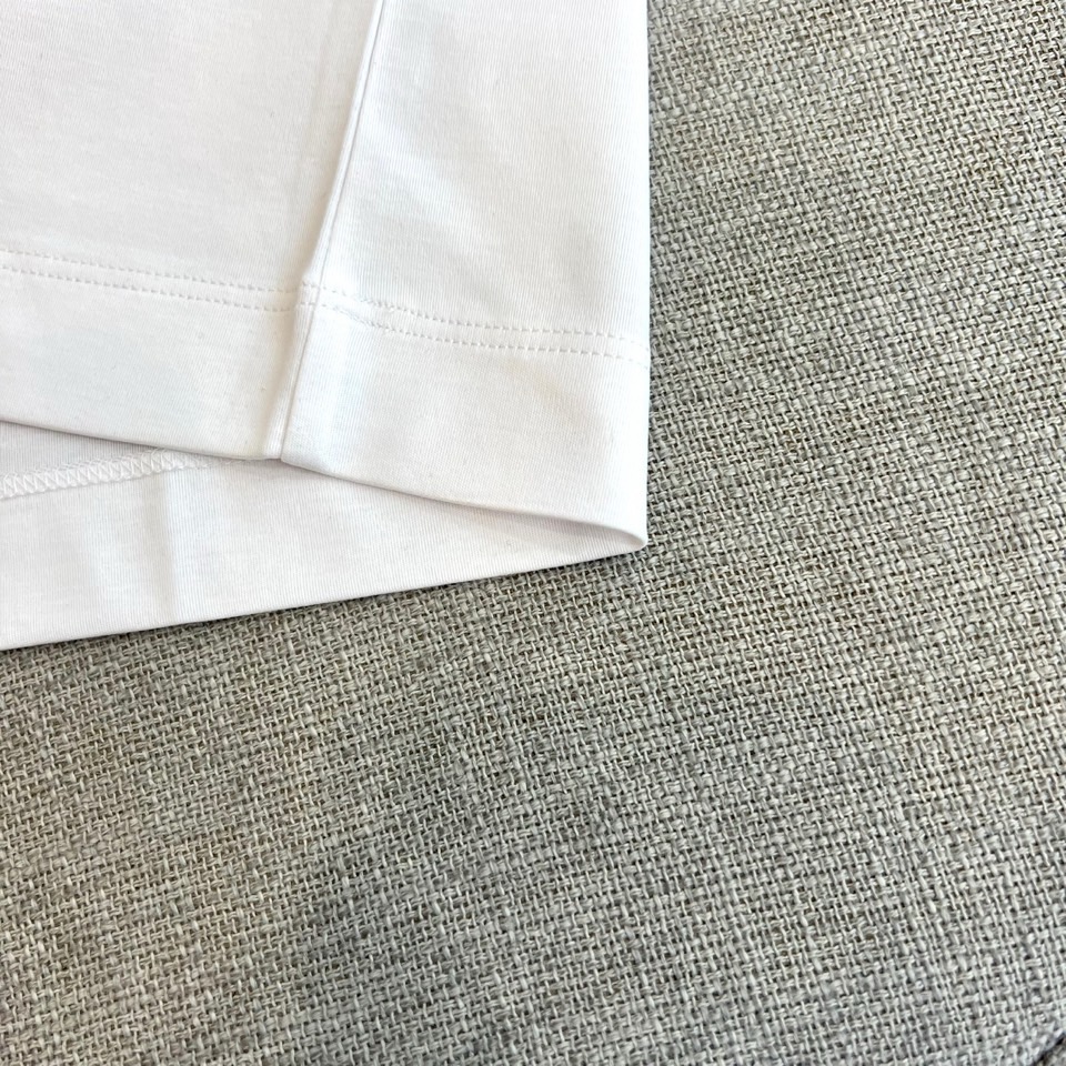 Mon蒙口、2026春夏新品短袖T恤，以纯色为基底，诠释极简主义美学。领子上精致字母标识点缀，低调彰显品