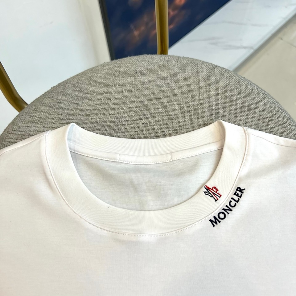 Mon蒙口、2026春夏新品短袖T恤，以纯色为基底，诠释极简主义美学。领子上精致字母标识点缀，低调彰显品