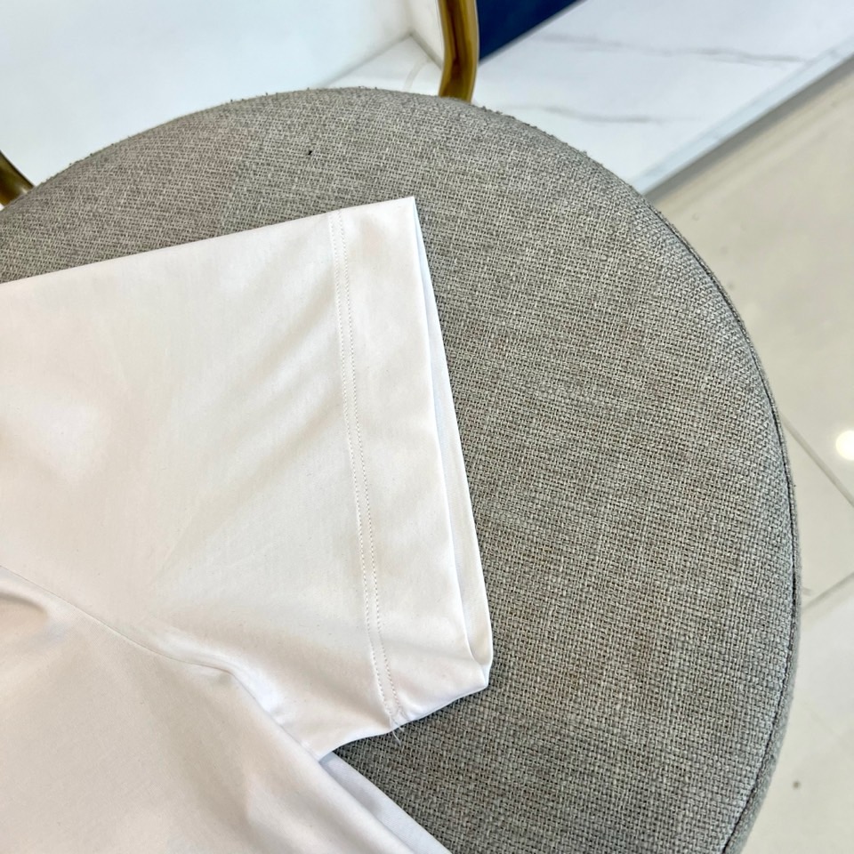 Mon蒙口、2026春夏新品短袖T恤，以纯色为基底，诠释极简主义美学。领子上精致字母标识点缀，低调彰显品